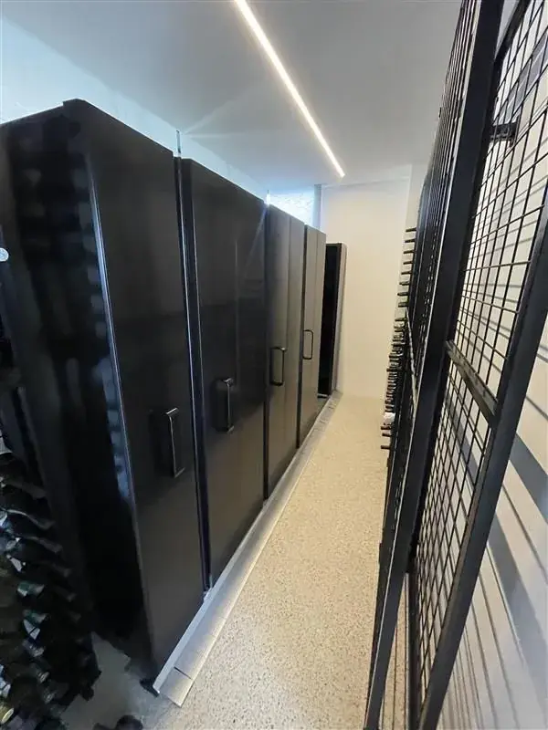 Black mobile archive shelving units beside a safety barrier